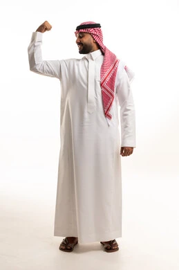 رجل سعودي بالزي التقليدي يستعرض عضلاته وقوته