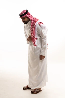 A Saudi man in traditional white attire in a studio.