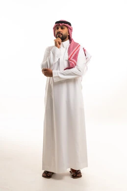 A Saudi man in a white thobe with an expression on his face that indicates confusion.