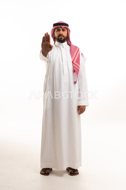 رجل سعودي بالثوب التقليدي يشير بعلامة التوقف