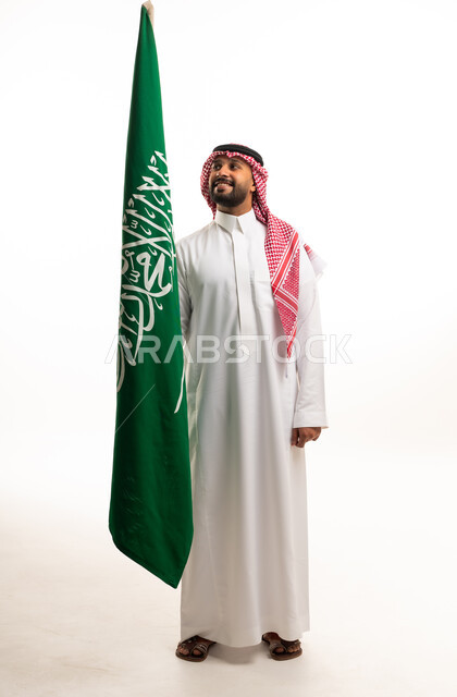 Saudi Man Holding Saudi Arabian Flag in Studio