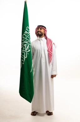 Saudi Man Holding Saudi Arabian Flag in Studio