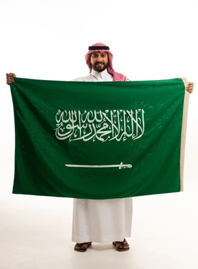 رجل سعودي يحمل علم السعودية خلفية بيضاء