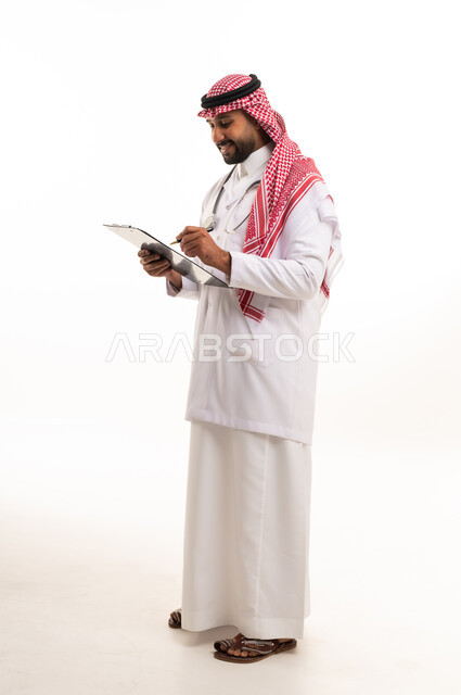 Saudi Male Doctor Writing on Clipboard in Studio