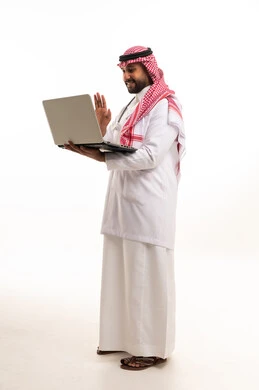 طبيب سعودي يحمل كمبيوتر محمول بالزي التقليدي