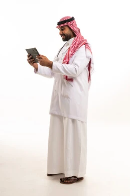 طبيب سعودي يرتدي المعطف الطبي ويستخدم جهاز تابلت رقمي