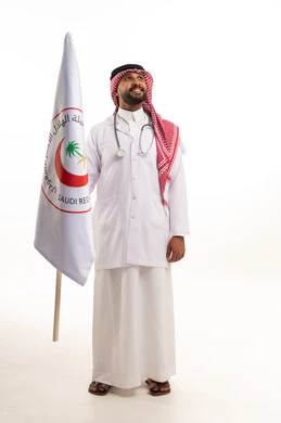 طبيب سعودي يحمل علم الهلال الأحمر في استوديو