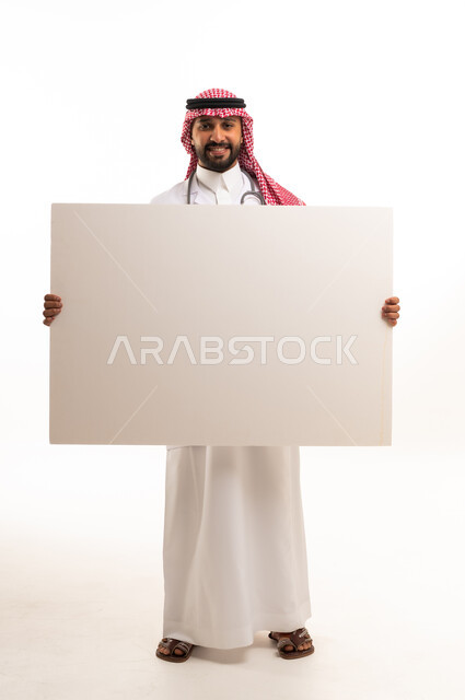 طبيب سعودي يرتدي الزي التقليدي يمسك لوحة بيضاء فارغة