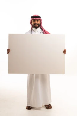 طبيب سعودي يرتدي الزي التقليدي يمسك لوحة بيضاء فارغة