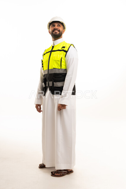 A Saudi engineer in a thobe and safety helmet.