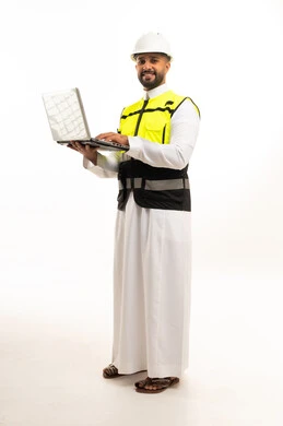مهندس سعودي يحمل لابتوب ويرتدي ملابس السلامة