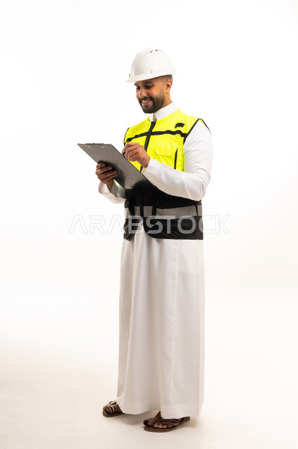 مهندس مدني سعودي يرتدي سترة السلامة ولوحة ملاحظات