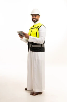 مهندس سعودي يحمل جهاز لوحي بمعدات السلامة