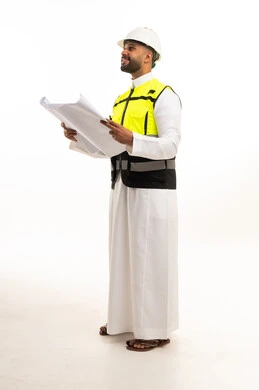 مهندس سعودي بالثوب يحمل مخططات هندسية في الاستوديو