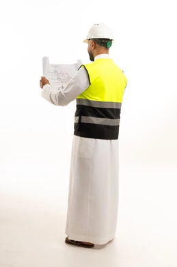 مهندس سعودي يحمل مخطط بناء بملابس السلامة