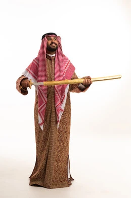 رجل سعودي بالبشت التقليدي يحمل سيفاً ذهبياً
