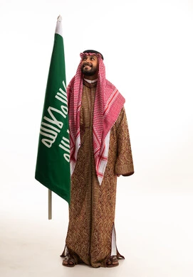 Saudi Man with National Flag in Traditional Clothing