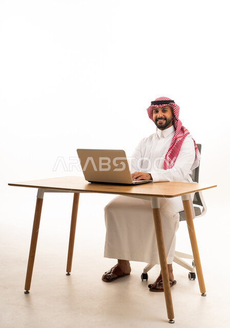 رجل سعودي يعمل على جهاز كمبيوتر محمول