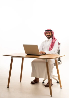 رجل سعودي يعمل على جهاز كمبيوتر محمول