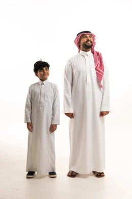 أب سعودي وابنه بالزي التقليدي ينظران للأعلى