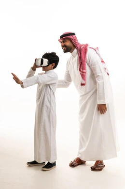 رجل وطفل سعوديان يستخدمان نظارة الواقع الافتراضي
