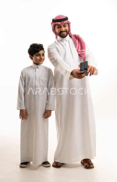 رجل سعودي وابنه يستخدمان هاتف ذكي خلفية بيضاء