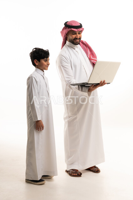 رجل سعودي وطفل يستخدمان كمبيوتر محمول خلفية بيضاء