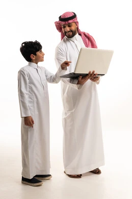 Saudi Man and Boy Using Laptop in Traditional Clothing
