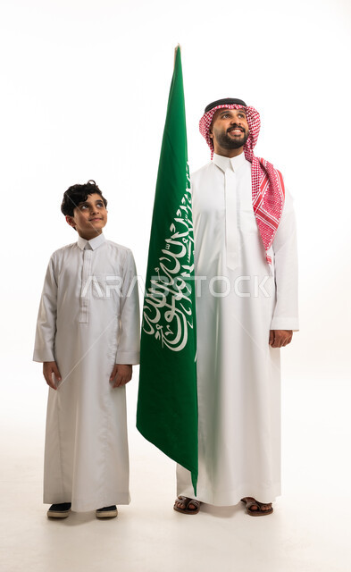 رجل وطفل سعودي مع العلم الوطني بخلفية بيضاء