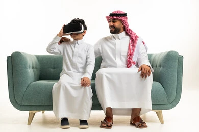 Saudi Man and Boy with VR Headset on Sofa