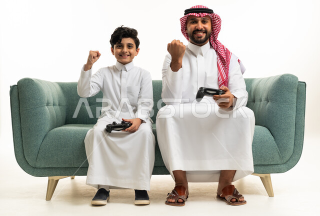 أب سعودي وابنه يلعبان ألعاب الفيديو على الأريكة