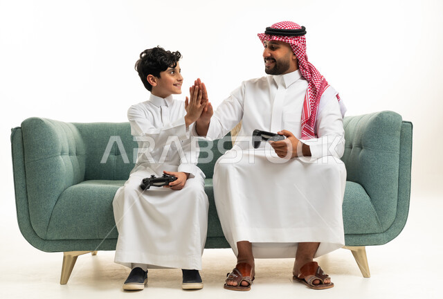 أب سعودي وابنه يلعبان ألعاب الفيديو على الأريكة