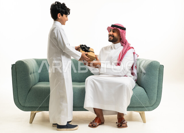 أب سعودي يستلم هدية من ابنه على الأريكة