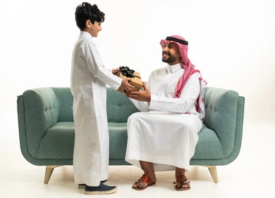 أب سعودي يستلم هدية من ابنه على الأريكة