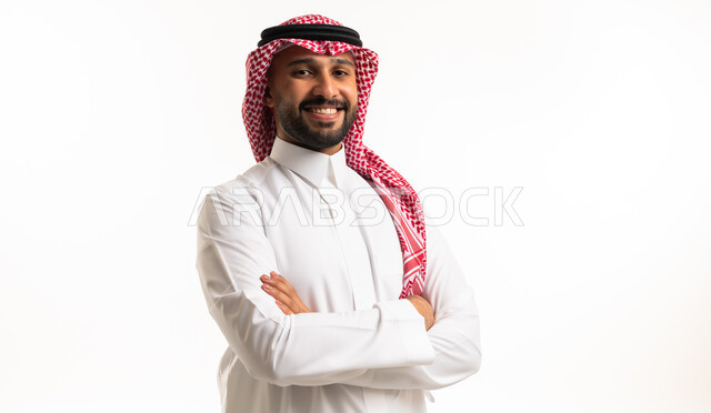 رجل سعودي مبتسم بالثوب التقليدي والشماغ الأحمر
