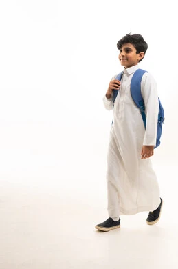 طالب سعودي بالثوب التقليدي يحمل حقيبة مدرسية