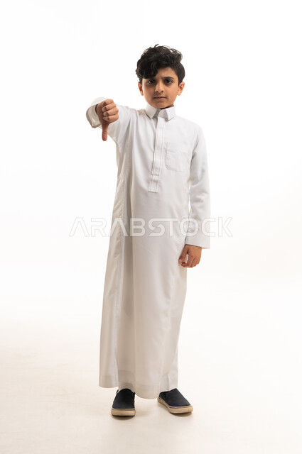 Saudi Boy in White Thobe Making Thumbs Down Gesture