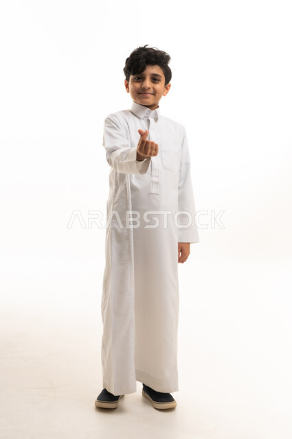Saudi Boy in White Thobe Making Finger Heart Gesture