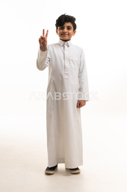 Saudi Boy in White Thobe Making Peace Sign
