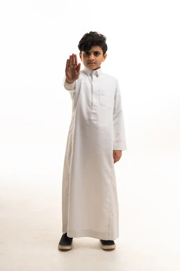 طفل سعودي بالثوب الأبيض يقوم بإشارة التوقف باليد