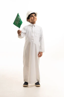 طفل سعودي يحمل العلم ويرتدي خوذة مهندس خلفية بيضاء