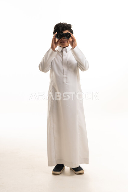 Saudi Boy in Traditional Thobe Using Binoculars