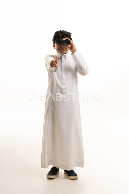 طفل سعودي بالثوب الأبيض يحمل منظاراً