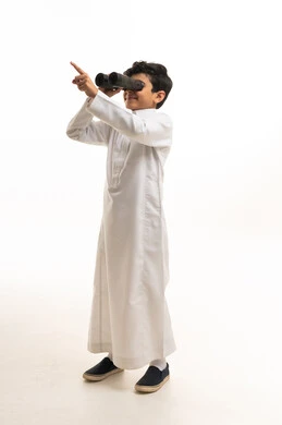 طفل سعودي بالثوب التقليدي يحمل منظار