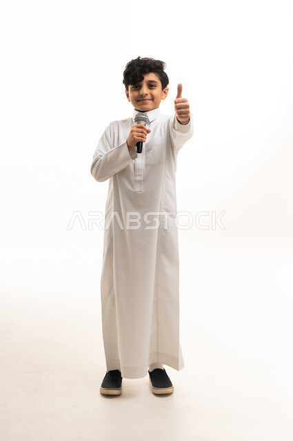 Saudi Boy in White Thobe Holding Microphone and Thumbs Up
