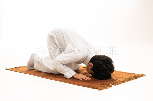 Young Saudi Boy Performing Sujud Prayer on White Background