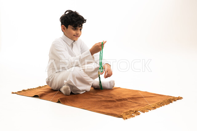 Saudi Boy in White Thobe with Prayer Beads