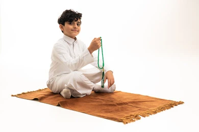 Saudi Boy in White Thobe with Prayer Beads