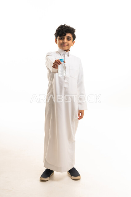 Saudi Boy in Traditional Thobe Holding Water Bottle