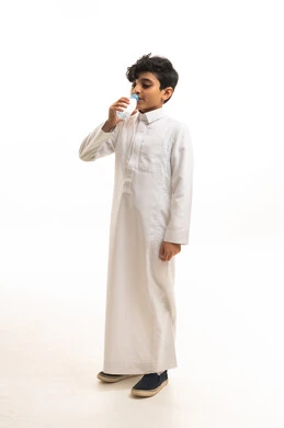 Saudi Boy in White Thobe Drinking Milk on White Background